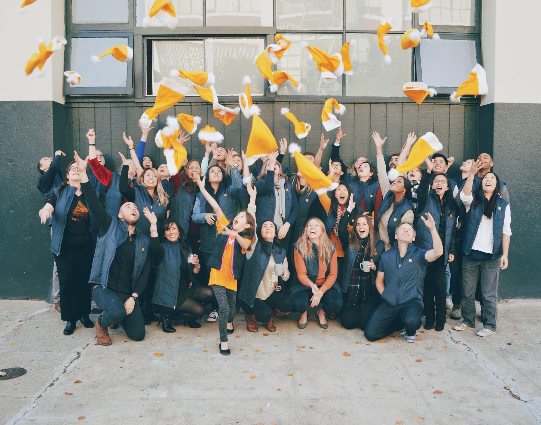 The Honor team throwing orange santa hats